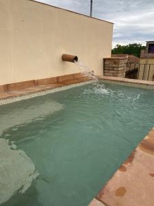 a pool of water with a pipe pouring water into it at Cal Sabater, Empordà-Costa Brava in Báscara