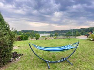 a hammock sitting in a field of grass at Agroturystyka Nad Jeziorem Klocek w Borach Tucholskich in Klocek +19 photos