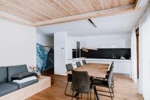 a kitchen and dining room with a wooden table and chairs at Am Heimberg Skilift - Mullers x Kandahar Suite in Parpan
