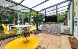 a conservatory with glass walls and a table and a tv at Beautiful Home In Baarland With Wifi in Baarland +17 photos