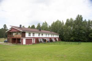 a large house with a grassy field in front of it at Nature Escape in Lahemaa Bright 1-Bedroom Apartment with Terrace in Kolga