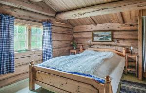 a bedroom with a bed in a log cabin at 2 Bedroom Stunning Home In Sel in Rosti +6 photos