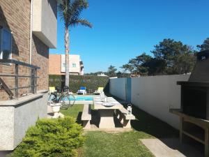 un cortile con tavolo da picnic e piscina di Casa do Sol - Entre o Mar e o Pinhal ad Apúlia