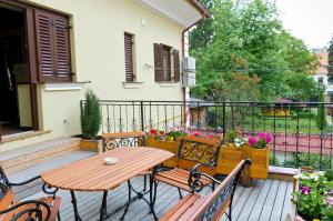 a patio with a wooden table and benches on a balcony at Arina Apartments in Braşov