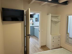 ラス・アレーナス・デ・カブラレスにあるApartamentos San Roqueのキッチン(壁に薄型テレビ付)