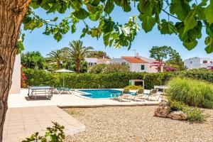 a pool in a yard with chairs and a table at Villa Bini Anna by Villa Plus in Binibeca