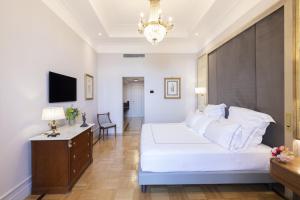 a bedroom with a large white bed and a chandelier at Grand Hotel Parker's in Naples