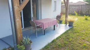 a pink table and chairs on a patio at maison proche du lac in Aureilhan