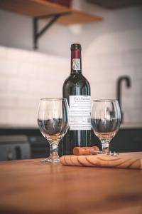 a bottle of wine and two wine glasses on a table at Kape Loft in Cape Town +40 photos