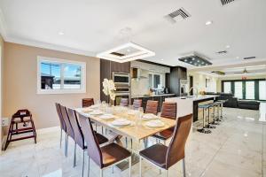 ein Esszimmer und eine Küche mit Tisch und Stühlen in der Unterkunft Luxury 4BR & 4BA Villa Heated Pool Minutes To Beach in Hollywood