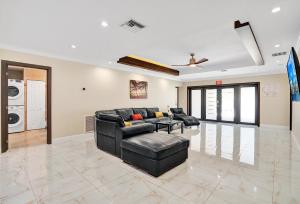 ein Wohnzimmer mit einer schwarzen Couch und einem Tisch in der Unterkunft Luxury 4BR & 4BA Villa Heated Pool Minutes To Beach in Hollywood