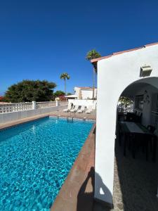 ein Schwimmbad mit einem Torbogen neben einem Gebäude in der Unterkunft Villa Sole# Luxury Amarilla Golf in San Miguel de Abona