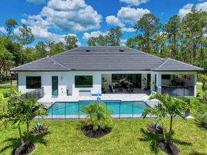a house with a swimming pool in a yard at Quiet 5-br House Heated Pool And Outdoor Kitchen in Naples