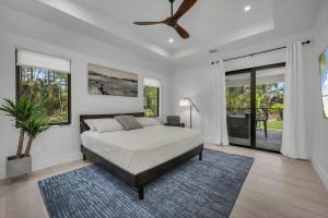 a bedroom with a bed and a ceiling fan at Quiet 5-br House Heated Pool And Outdoor Kitchen in Naples +32 photos