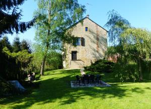 a building in the middle of a yard with chairs at Gite de l'ecole in Rubécourt-et-Lamécourt
