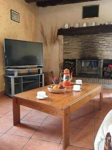 a wooden coffee table in a living room with a fireplace at La ferme d'ernest in Marnay