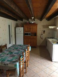 a kitchen with a table and a kitchen with a refrigerator at La ferme d'ernest in Marnay