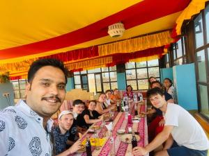 a man sitting at a table with a group of people at Hotel Renuka in Jaisalmer