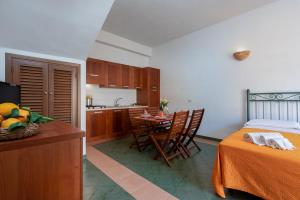 a kitchen and a bedroom with a table and a bed at Case vacanza Al Paradise in San Vito lo Capo +5 photos