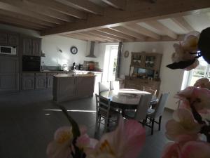 a kitchen and dining room with a table and chairs at Gîte de la haute roche in Charroux