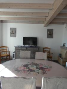 a dining room with a table with chairs and a fireplace at Gîte de la haute roche in Charroux