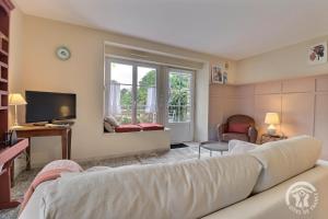 a living room with a couch and a television at Les hortensias in Feins