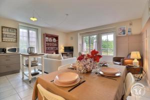 a kitchen and living room with a table and chairs at Les hortensias in Feins