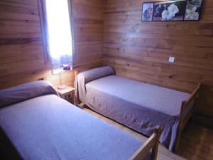 a bedroom with two beds and a window and a lamp at La callune in Brocas