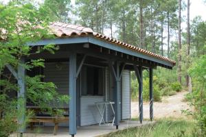 a small cabin with a roof on a porch at La callune in Brocas