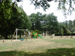 a park with a swing set in the grass at La callune in Brocas +3 photos