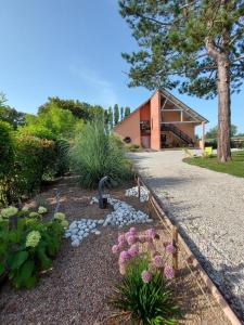 a garden with flowers and plants in front of a building at Aux couleurs du lac in Géraudot