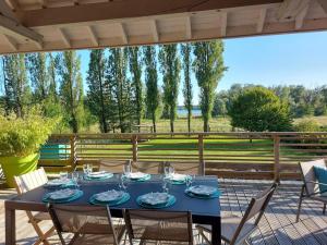 a blue table with glasses and chairs on a patio at Aux couleurs du lac in Géraudot +13 photos