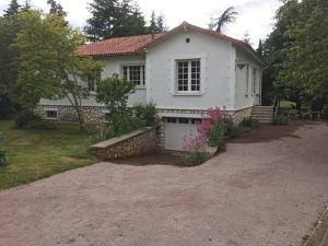 a white house with a driveway in front of it at Gîte du parc in Chaunay