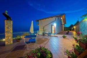 patio z krzesłami i stołami w nocy w obiekcie Villa il Dolce Tramonto w mieście Furore