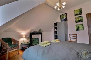 a bedroom with a large bed and a chair at Villa thi bai in Saint Malo