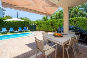 a patio with a table and chairs and a pool at Villa Paraíso in Alcudia