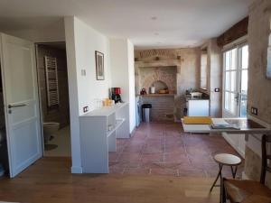 a kitchen and living room with a counter and a table at Le studio de saint-maixent le petit in Haims