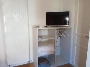a tv sitting on top of a white shelf at Le studio de saint-maixent le petit in Haims