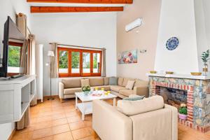 uma sala de estar com um sofá e uma lareira em Villa Caterina by Villa Plus em Alaior
