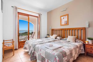 um quarto com duas camas e uma varanda em Villa Caterina by Villa Plus em Alaior mais 23 fotografias