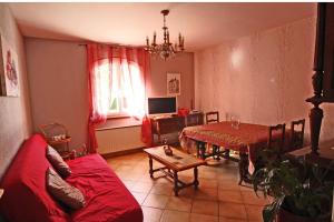 Una sala de estar con un sofá rojo y una mesa. en Bel air, en Nexon