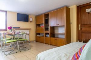 a bedroom with a bed and a table with chairs at Gîte la parro 2/4 personnes in Cultures