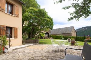 a patio with chairs and tables in a yard at Gîte la parro 2/4 personnes in Cultures