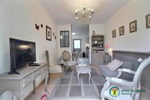 Una sala de estar con un sofá y un televisor. en Ty mam goz, en Auray