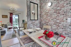 cocina y sala de estar con pared de ladrillo en Ty mam goz, en Auray