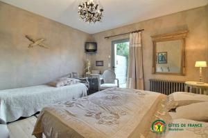 Un dormitorio con dos camas y una mesa y una ventana. en Ty mam goz, en Auray