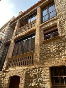 a stone building with windows and a balcony at Cal Sabater, Empordà-Costa Brava in Báscara +59 photos