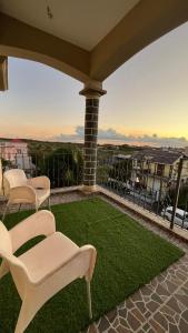 d'une terrasse avec des chaises et de la pelouse sur un balcon. dans l'établissement Cozy Apartment with Pool & 10 mins walk to Beach, à Mont Choisy