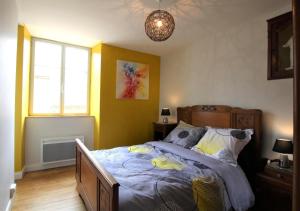 a bedroom with a bed with yellow walls at Chez zézé in Asson