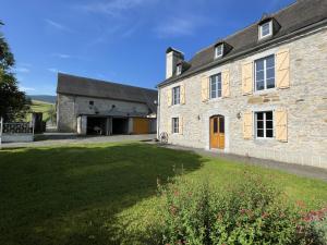 a large stone building with a grass yard at Chez zézé in Asson